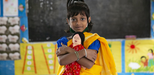 CH1652792 Portrait of Amina 6 holding a doll in her classroom at school in Rajbari District Bangladesh