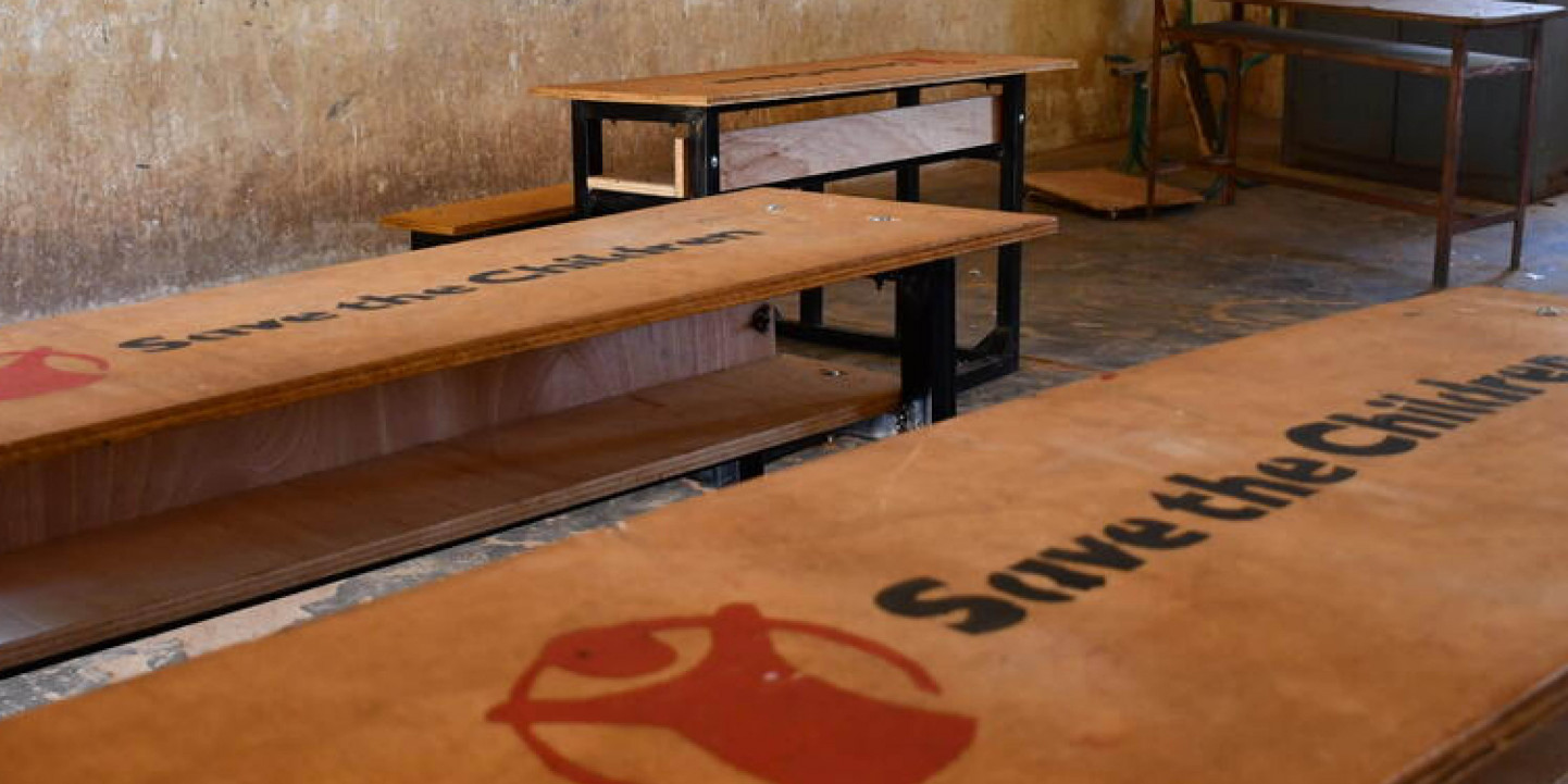 empty desks with Save the Children logo