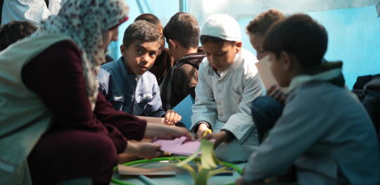 CH11541854 Teacher Asya sits making Ramadan lanterns with students