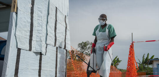 CH11594885 A health worker, Geremi (42), disinfects an area around the Ebola treatment centre with chlorinated water solution