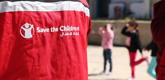 CH11557081 Save the Children staff do group exercises outdoors at a Child Friendly Space (1)