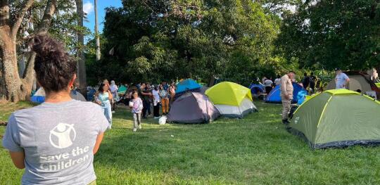CH11612466 Save the Children staff visit a park where families are camping