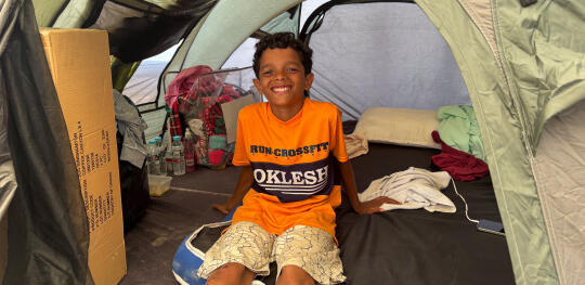 CH11620973 Jose (11) sits in a tent where he has been staying since the earthquakes