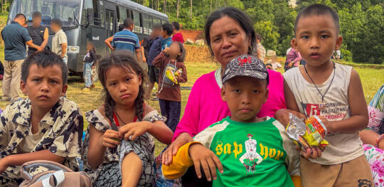 CH11660491 Amita (56) and her granchildren sit outside a holding centre in Nepal (1)