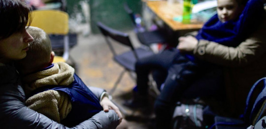 CH1654297 26022022   Parents with their two sons aged five and eight years old sheltering inside a school in Kyiv Ukraine