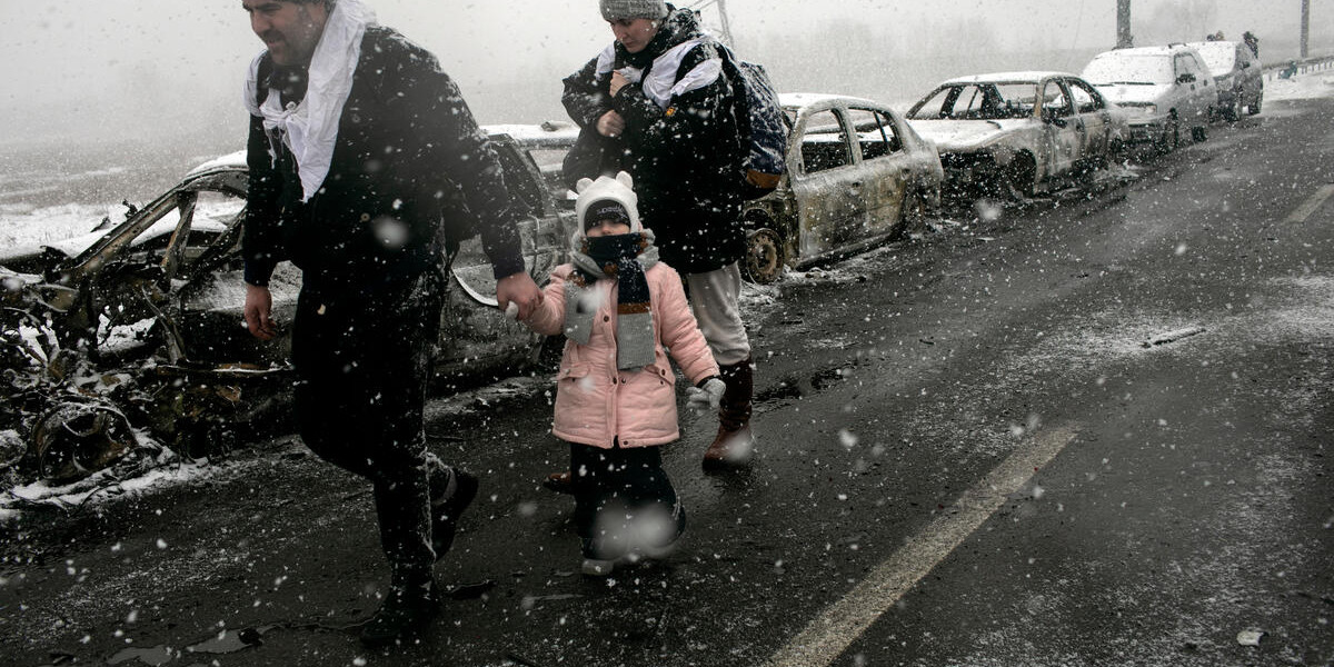 CH1657796 MEDIA USE ONLY A Ukrainian family fleeing Irpin under the snow after the city was hit by shelling