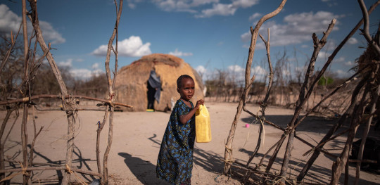 CH1697145 Hafsa 3 drinks from a jerry can outside her home in a drought hit village in Garissa County northern Kenya