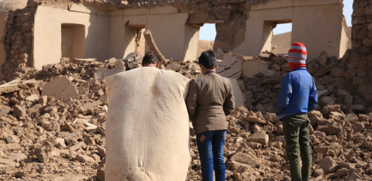 CH1887819 Three children look at earthquake rubble