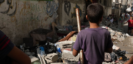 CH1909312 A child standing among a pile of rubble on a street in Gaza