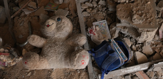 CH1909346 A childs school backpack and a doll among a rubble in Gaza 1