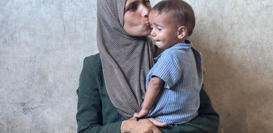 CH11424821 Radwa, kisses her daughter, Basma's forehead