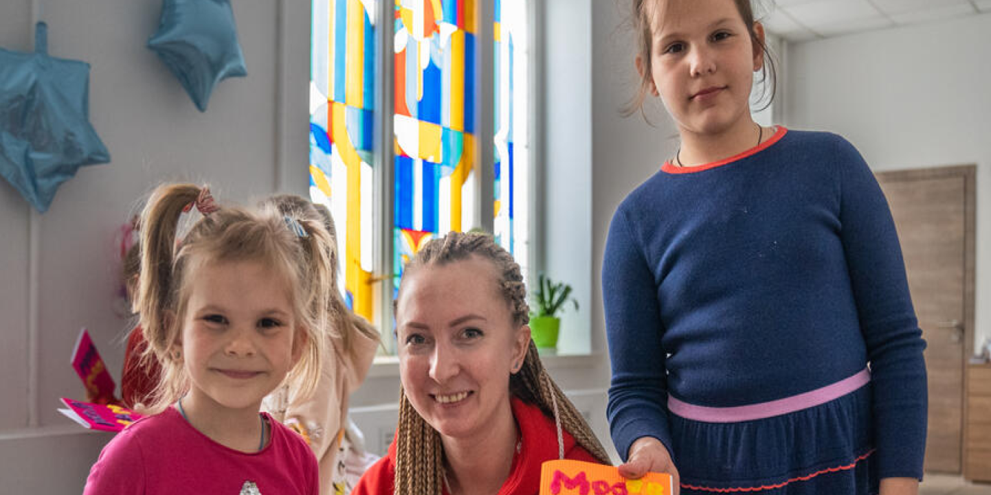 carousel image 1CH1818312 Olga Shults Save the Childrens programme manager poses for portrait with Marta holding gift cards at Child Friendly Space in Mykolaiv U