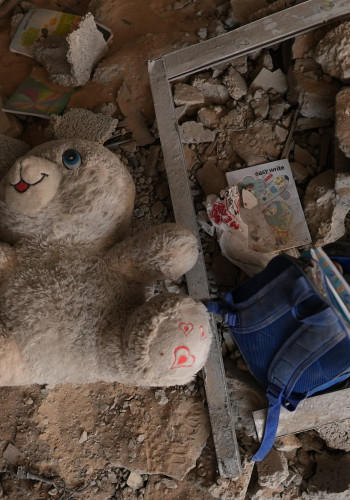 CH1909346 A childs school backpack and a doll among a rubble in Gaza 1 v2
