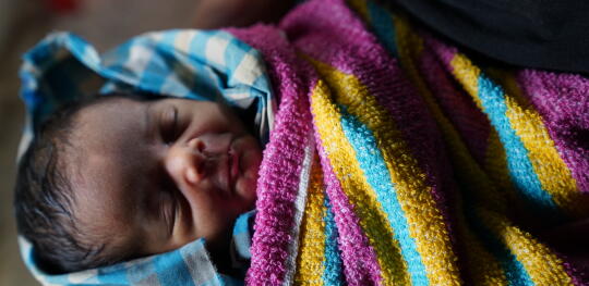 CH1820271 Newborn baby Sahida being held by her grandmother Nur Halima at the family shelter