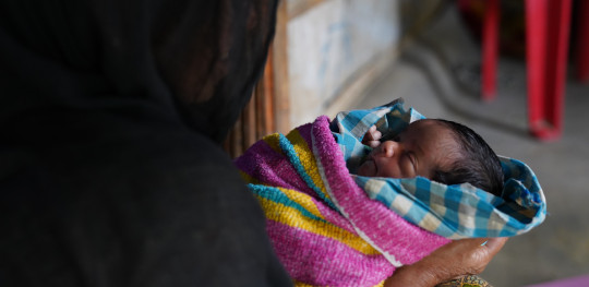 CH1820282 Newborn baby Sahida being held by her grandmother Nur Halima at the family shelter