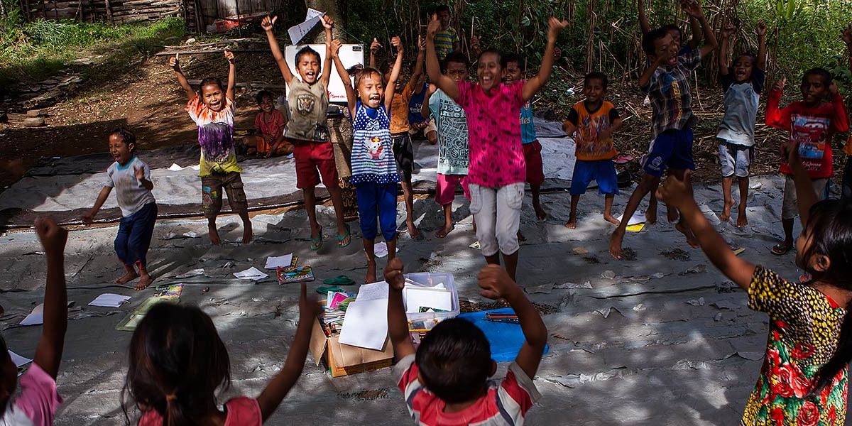 children gather in the shade