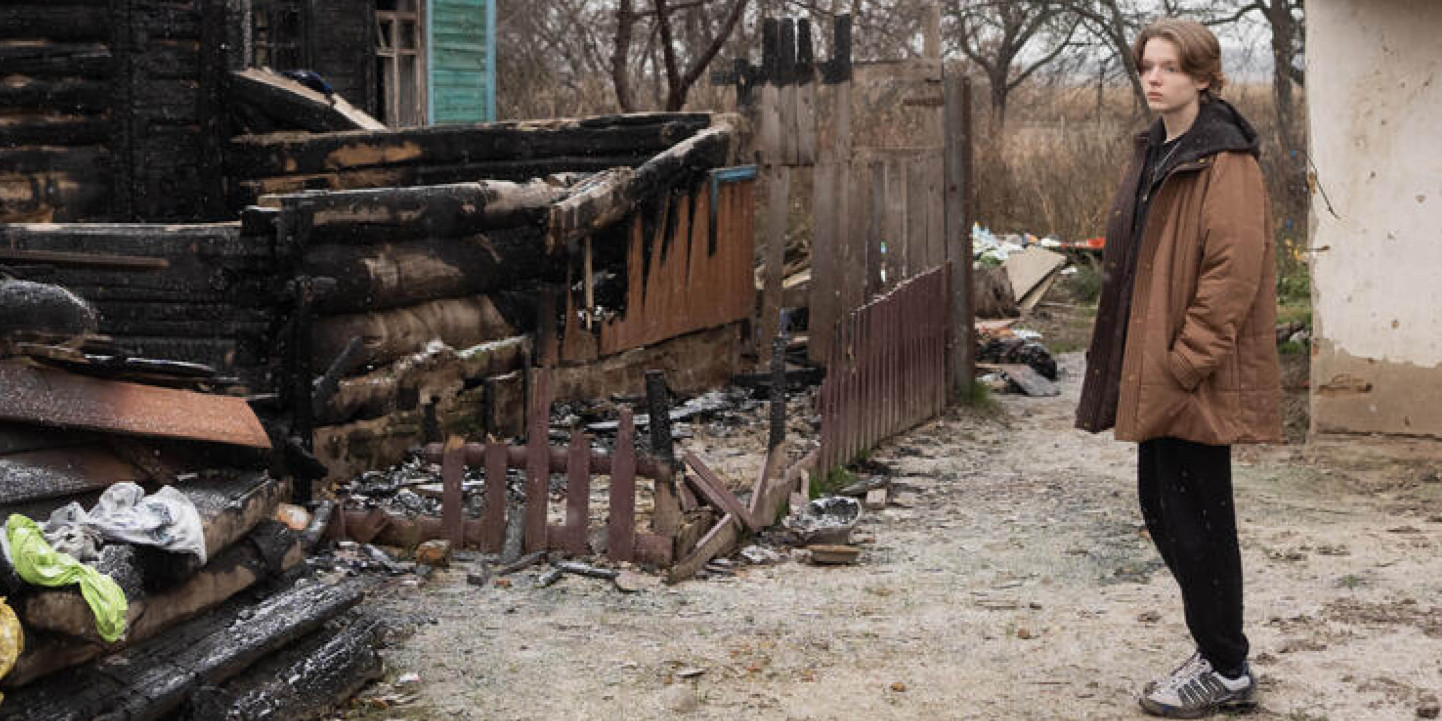 Dmytro 15 stands in the garden of his former home Ukraine