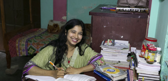 CH1651556 Bobita 24 works at her desk at the Save the Children run safe house where she now works as a Mentor in Rajbari District Bangladesh