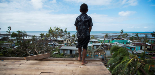 Boy overlooking damage